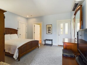 Quarto com cama, escrivaninha, cadeira, cómoda e porta.