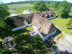 A large, historic building with a prominent central tower and a smaller adjacent structure. - Haus Fresenhagen (Stadum)