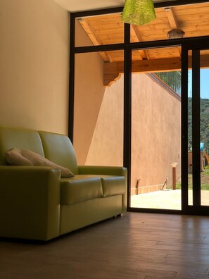 Habitación familiar, 2 habitaciones, vistas al jardín | Sala de estar | Una televisión de pantalla plana