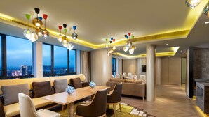 Una sala de estar moderna con comedor, ventanas amplias y vista a la ciudad.