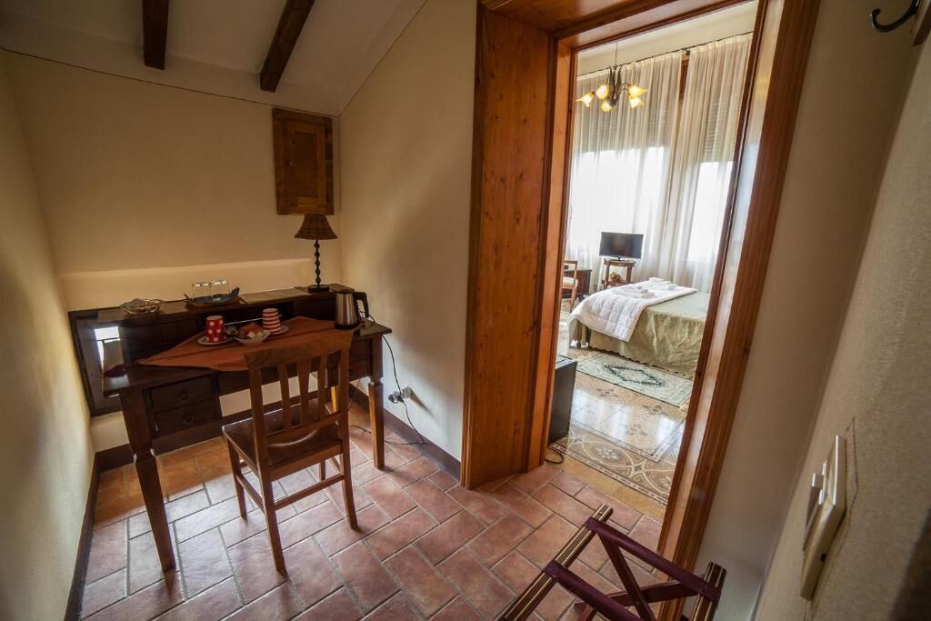 Una stanza compatta con una scrivania, una sedia e un letto.