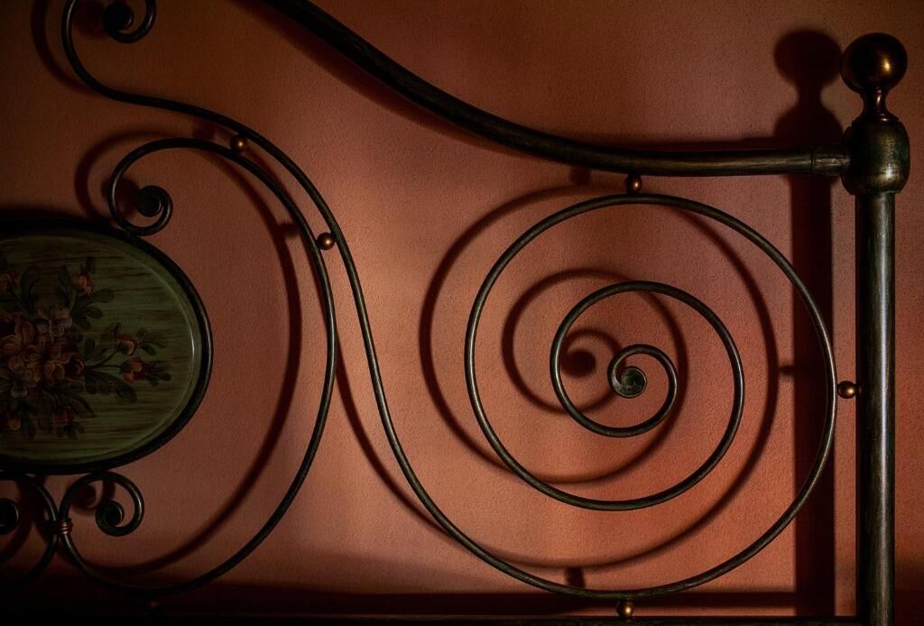 Eine Metall-Wendeltreppe mit einem grünen Tisch, der mit floralen Mustern verziert ist.