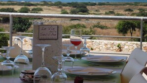 A table set for dining with a sign reading "Le Vie delle Secche restaurant" and a view of the sea in the background. - Scialabà (Salve)
