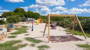 An outdoor play area with a swing set, slide, and climbing structures. - Scialabà (Salve)
