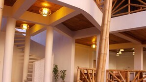 A modern interior with a staircase, bamboo railings, and a staircase leading to an upper level.