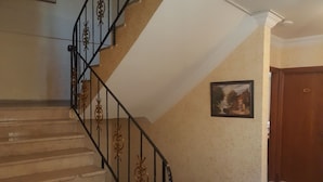 A staircase with ornate black railings and beige carpeted steps. - Florin Hotel (Istanbul)