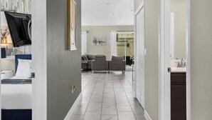 A hallway with a bed, a TV, a sofa, and a dining area. - 5 Bedrooms / 4 Bathrooms / Storey Lake (4955 WA) (Kissimmee)
