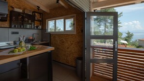 A modern kitchen with wooden walls and a large window.