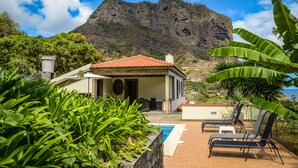 Une villa avec piscine, un espace salon extérieur et une vue sur la montagne.