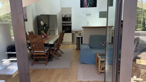 A modern interior with a dining area, kitchen, and seating space. - Large luxury apartment near the ocean with terrace between sea, golf course and lake  (Seignosse)