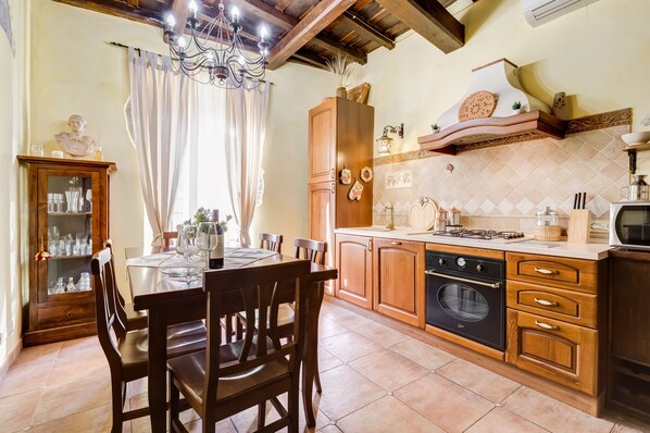 A kitchen with wooden cabinets, a dining table set for four, and a built-in oven.