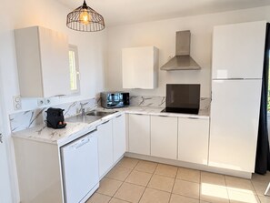 A modern kitchen with white cabinetry, a built-in dishwasher, a microwave, and a stove.