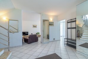 Ein modernes Interieur mit einer Treppe, einer Sitzecke und einem Fernseher.
