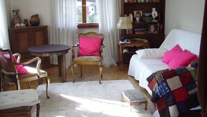 Um quarto aconchegante com uma cama, uma cadeira, uma mesa e uma estante de livros.