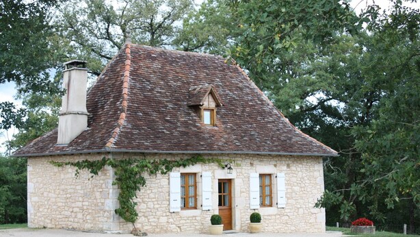 A stone house with a tiled roof, a chimney, and a small window. - Character cottage "les vieux chênes" very quiet near ROCAMADOUR and Gramat  (Théminettes)