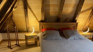 A bedroom with a wooden ceiling, a bed with a grey quilt, two bedside tables with round mirrors, and a wooden ladder. - Character cottage "les vieux chênes" very quiet near ROCAMADOUR and Gramat  (Théminettes)