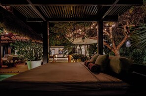 Ein Schlafzimmer mit einem Bett, einem Sofa und einem Essbereich mit Tisch und Stühlen.