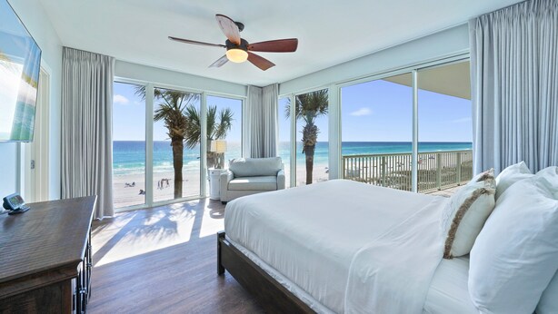 A bedroom with a large bed, a ceiling fan, and a view of the beach. - The Crescent 201 Beachfront Condo w/ Free Beach Service (Miramar Beach)