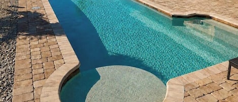 A heated pool, a lap pool, pool loungers