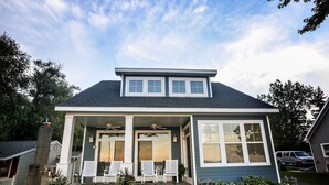 A single-story house with a covered porch, two windows, and a chimney. - AMAZING Lakefront And Well Designed Lakehouse: That Is Sure To Please (Romulus)