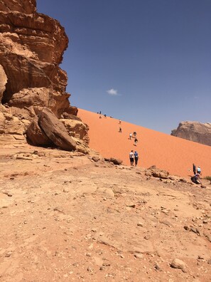 Wüstenlandschaft mit felsigem Gelände und blauem Himmel.