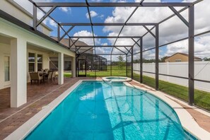 A swimming pool with a covered patio area, a hot tub, and a view of a residential neighborhood. - Villa Garcia - West Haven (Davenport)