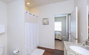 Une salle de bain avec douche, toilettes et lavabo.
