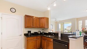 A kitchen with wooden cabinets, a dishwasher, and a countertop with various appliances.