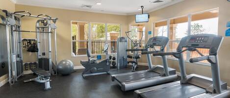 A gym with treadmills, elliptical machines, and weight machines.