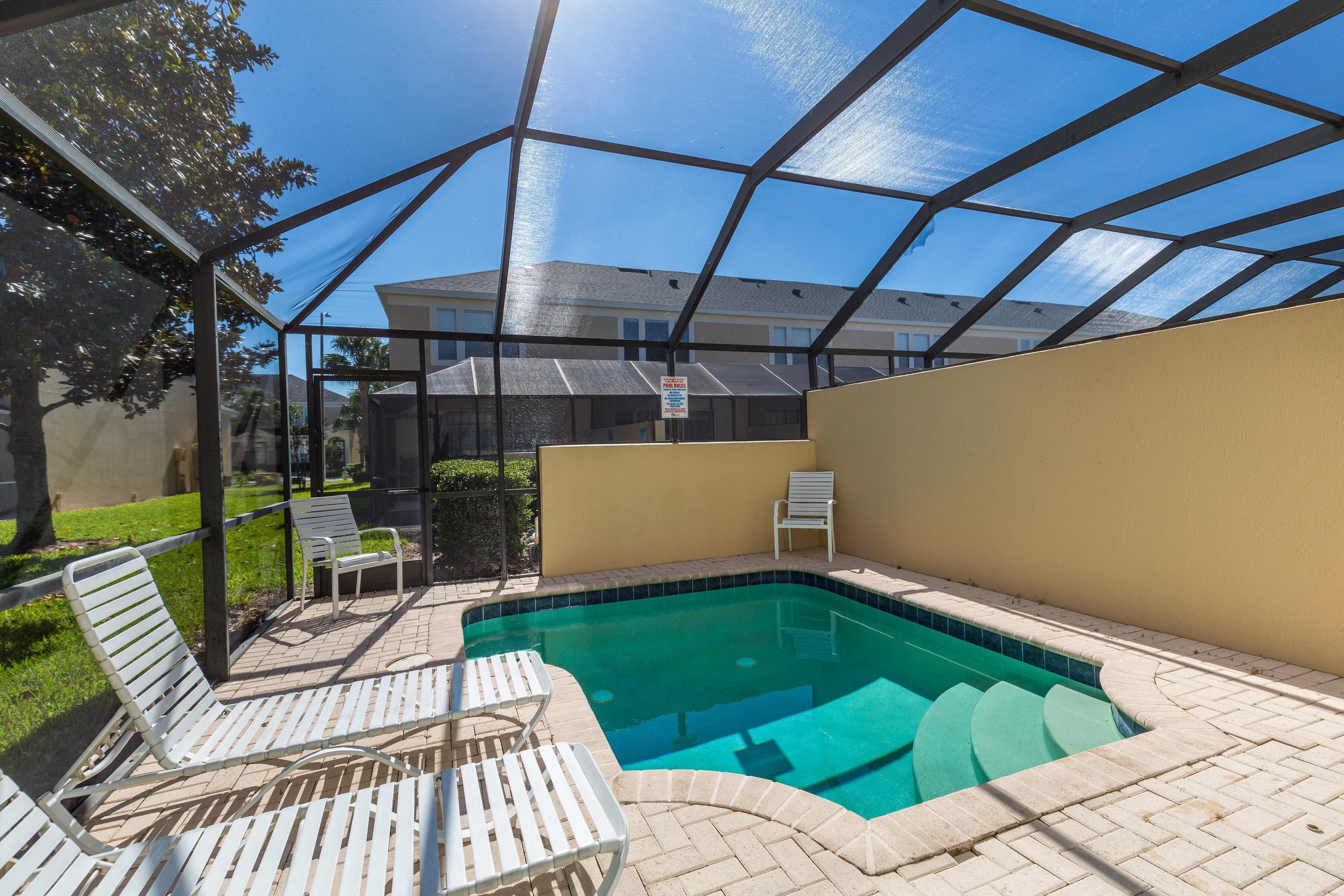 A swimming pool with lounge chairs and a covered patio area.