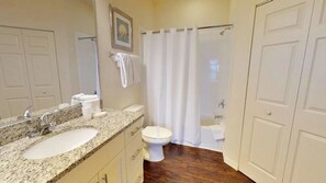 A bathroom with two sinks, a toilet, and a shower curtain. - Villa Nogueira - West Lucaya (Kissimmee)