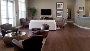 A spacious living room with leather sofas, a coffee table, and a TV on the wall. - Villa Guadalupe - West Lucaya (Kissimmee)