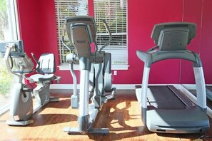 Ein Fitnessraum mit Cardiogeräten, darunter ein Crosstrainer, ein Ergometer und ein Laufband.