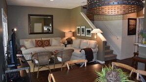 A living room with a sofa, chairs, a coffee table, and a staircase. - Villa Aventura - Lucaya Village (Kissimmee)