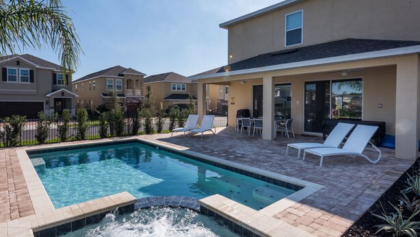 A residential pool area with a hot tub, lounge chairs, and a patio with a table and chairs. - Villa Veni Vici - Encore Resort at Reunion (Kissimmee)