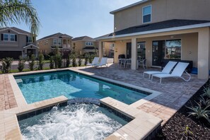 A residential pool area with a hot tub, lounge chairs, and a patio with a table and chairs. - Villa Veni Vici - Encore Resort at Reunion (Kissimmee)