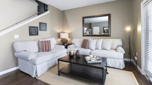 A living room with a sofa set, a coffee table, and a lamp. - Villa Gusta - Lucaya Village (Kissimmee)