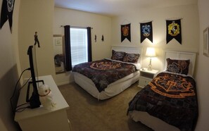 A bedroom with two beds, a desk, and a lamp. There are banners on the wall and a stuffed toy on the desk. - Villa Gatti (Lake Buena Vista)