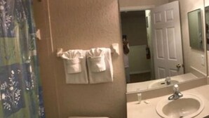 A bathroom with a sink, mirror, and towel rack. - Villa Teixeira (Davenport)