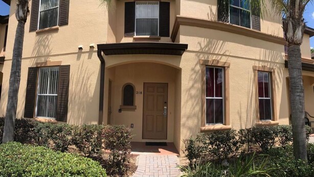 A two-story building with a beige facade, dark shutters, and a central entrance with a door marked '218'. - Villa Teixeira (Davenport)