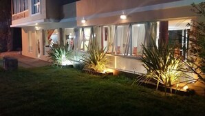 Un bâtiment moderne à deux étages, doté d’un patio couvert et d’une entrée bien éclairée.