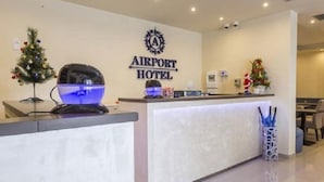 An airport hotel reception area with a reception desk, a Christmas tree, and a sign that reads "AIRPORT HOTEL". - Airport Garni Hotel Belgrade (Belgrade)