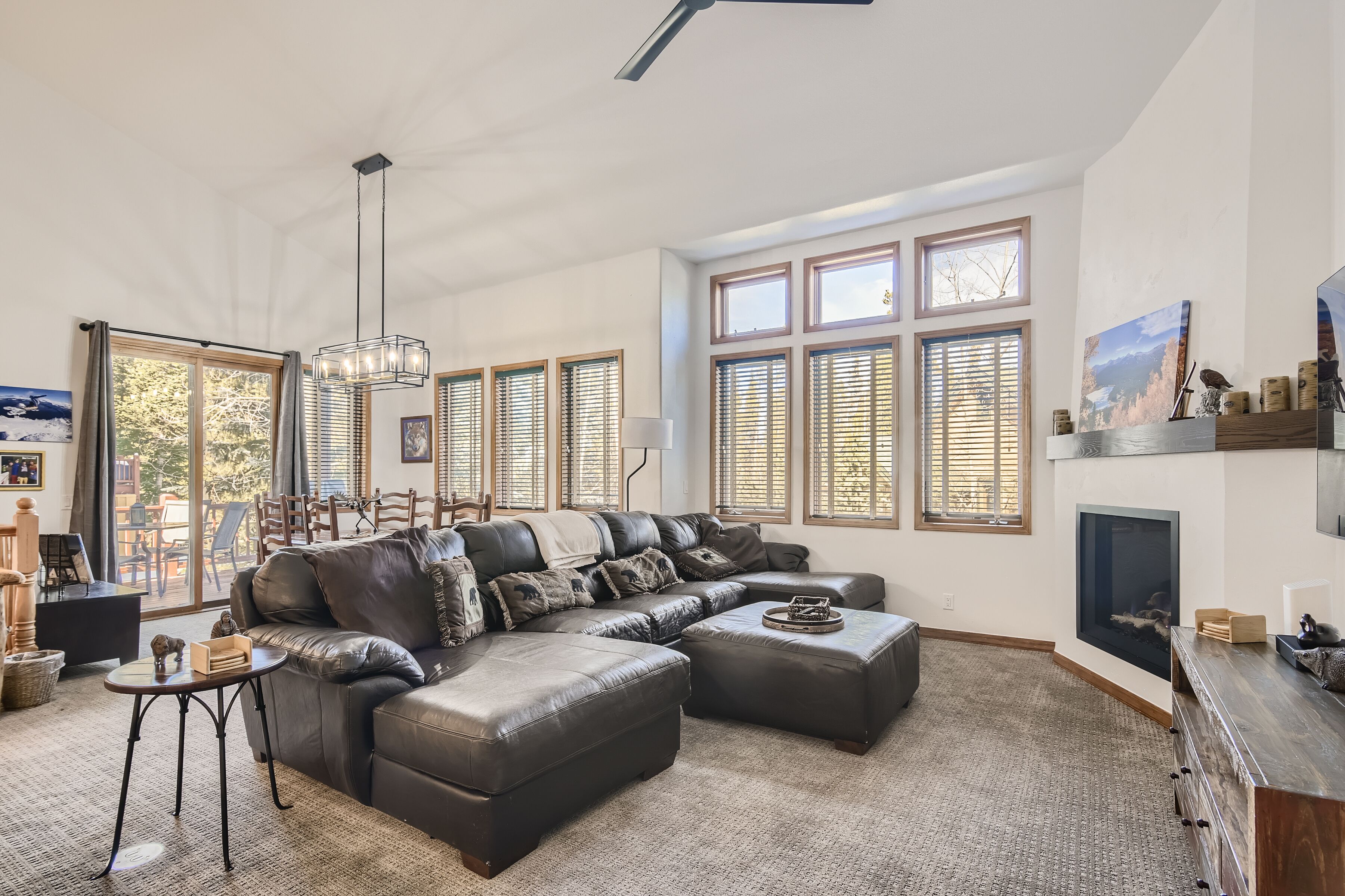A spacious living room with a large sectional sofa, a fireplace, and large windows.