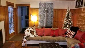 Una sala de estar acogedora con un sofá, un árbol de Navidad y una chimenea.
