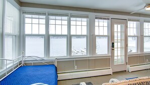 A room with large windows, a bed, and a view of a body of water. - Conesus Lake Front Retreat (Conesus)