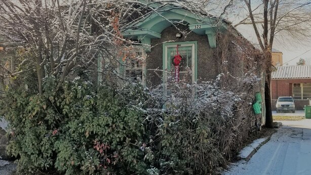 A building with a green facade and a door with a red decoration. - 30+Day Stay⭐Lovely Smarthouse King 4KTV W/D WIFI (Klamath Falls)