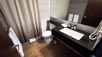 Un baño moderno con inodoro, lavamanos y espejo.
