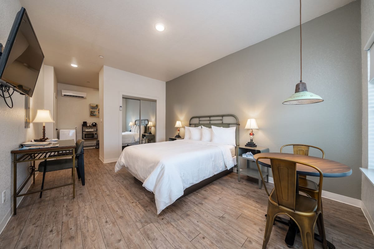 A bedroom with a bed, bedside tables, a desk, and a chair.