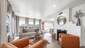 A modern living room with a sofa, leather armchairs, a coffee table, and a fireplace. - Best  Court (Hot Springs)