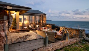 A stone house with a hot tub and outdoor seating by the sea. - Luxury  Beach House Rental with Hot Tub, 30 meters to Beach (Port wrinkle)